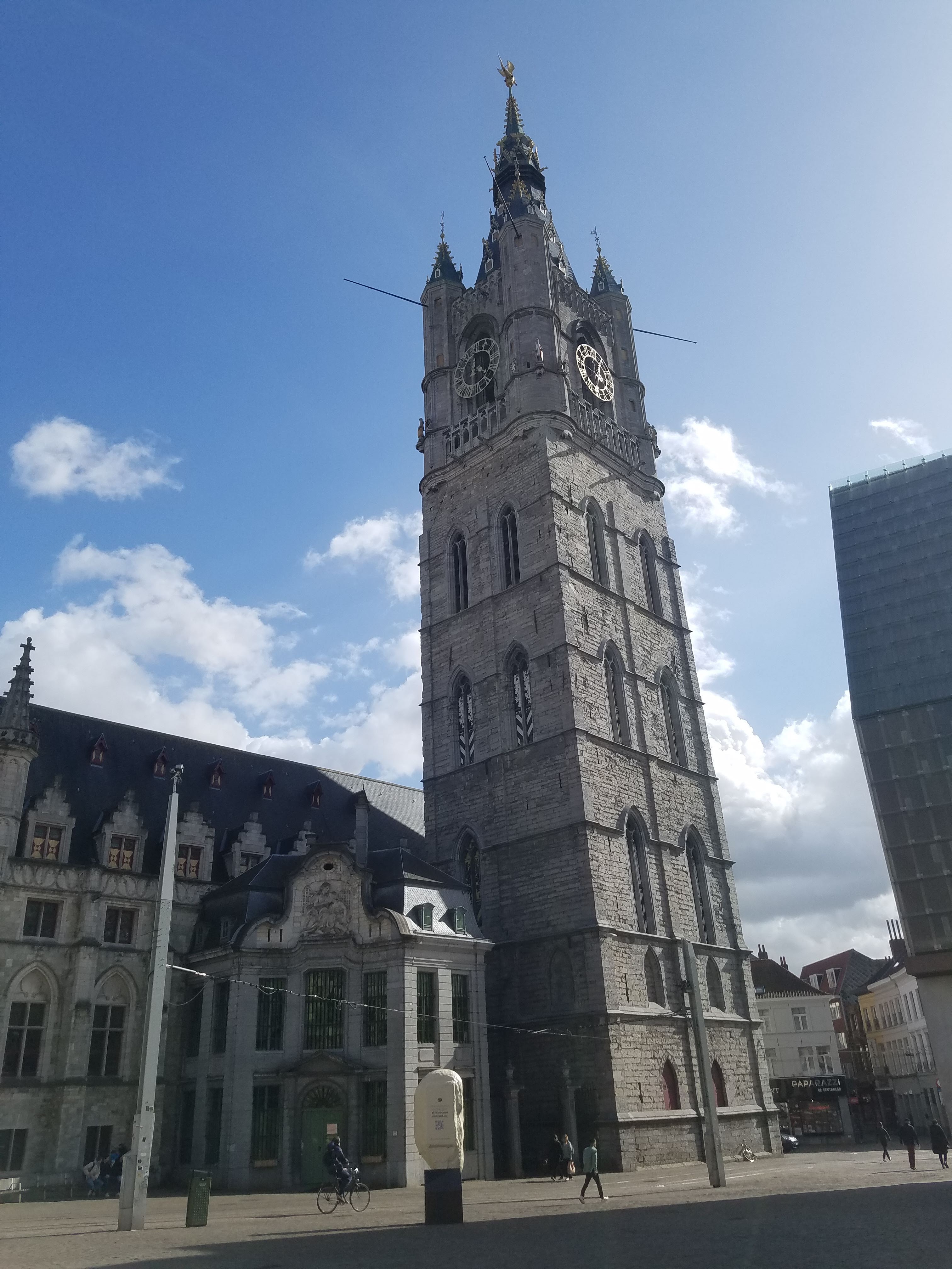 The massive, stone bell tower in Ghent looks magnificent on a sunny day