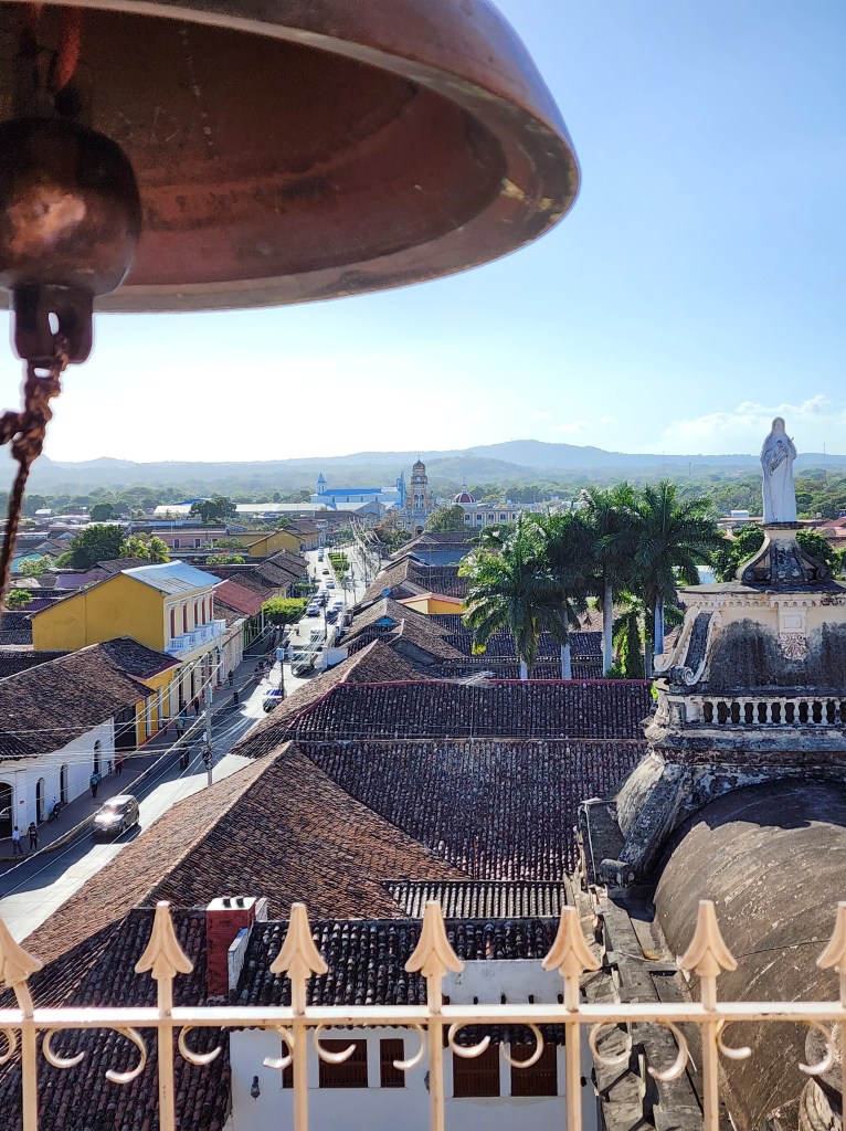 a church bell frames the view of Granada, Nicaragua from the church tower