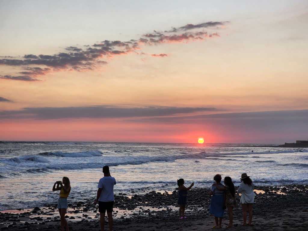 The sun goes down behind the pacific ocean at El Tunco Beach in El Salvador