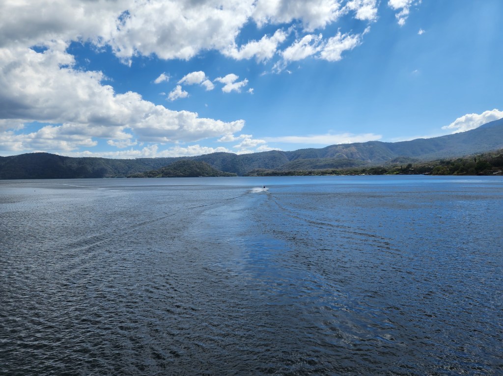 A jet ski disapears in the distance on a clear blue lake