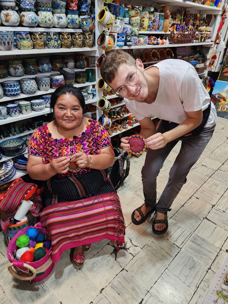A young backpacker in sandals poses with his handcrafted kippah in an artisan market in Antigua, Guatemala.