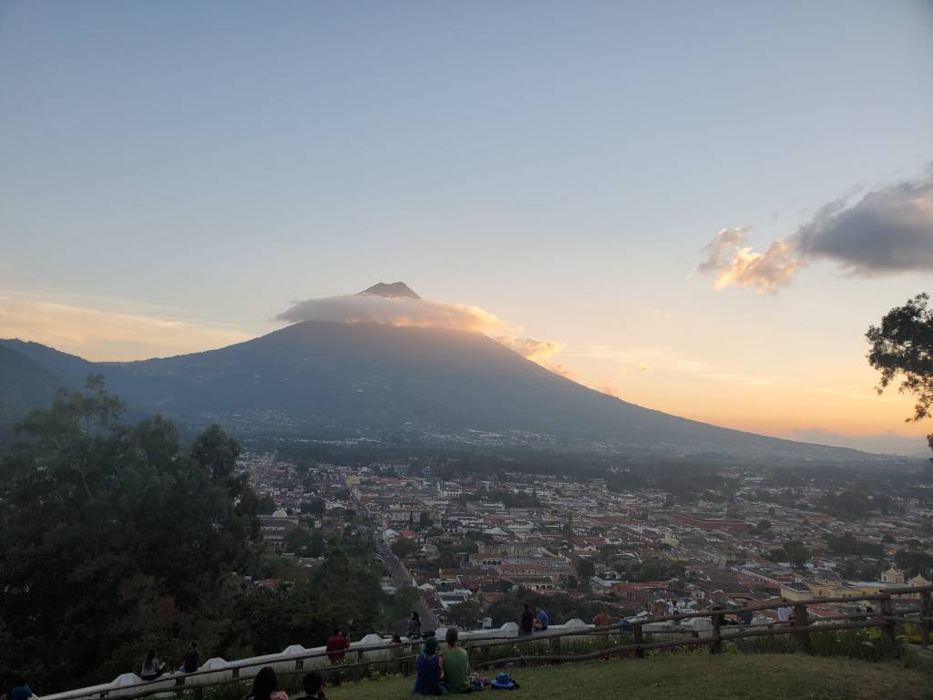 Clouds make a ring over the volcano Corazon del Agua in Atigua Guatemala. Framing the peak for a perfect photo. In front of the volcano the town spreads out in a stunning sunset