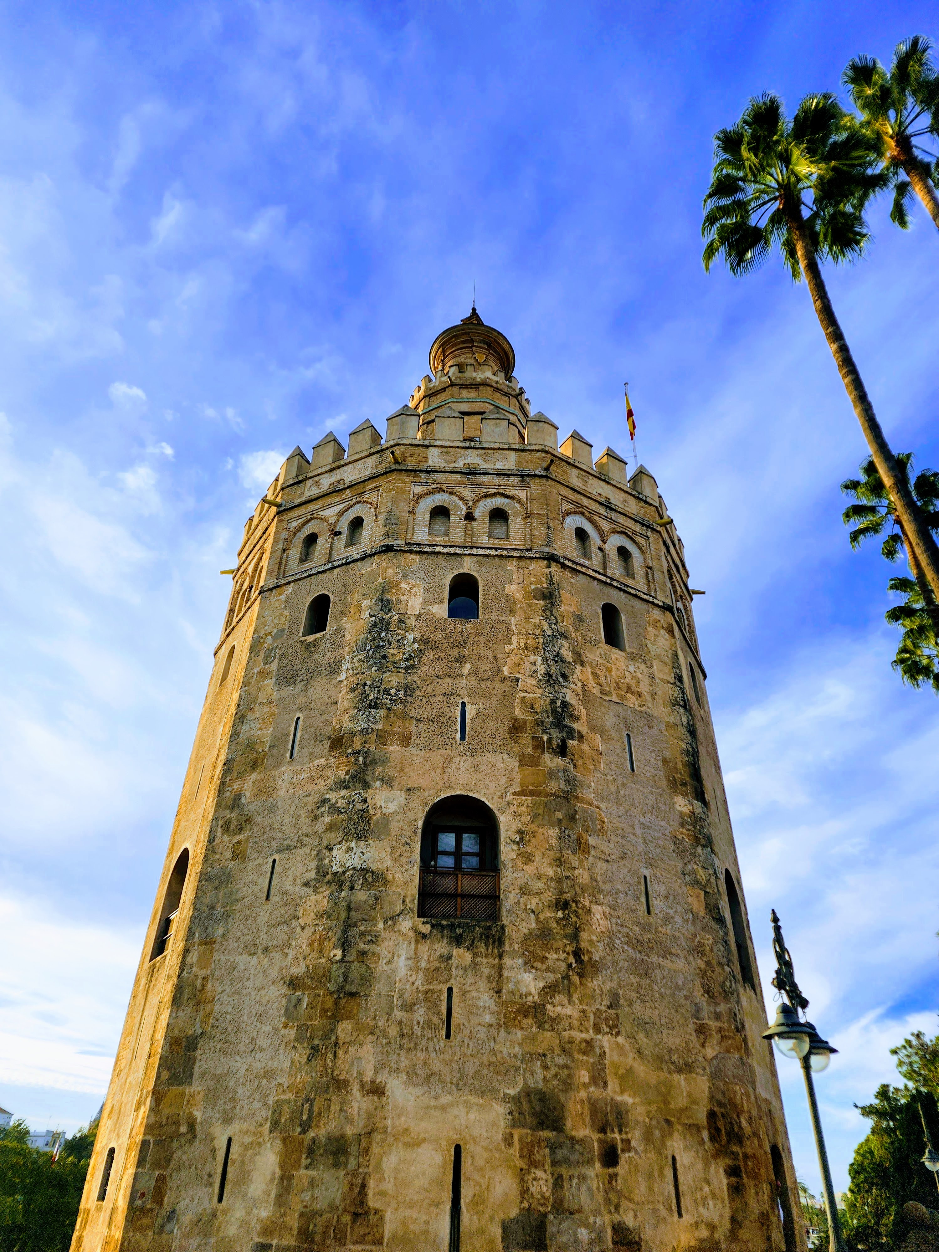 A stone tower punches out into the brilliant blue sky, with only palm trees to rival it's height.