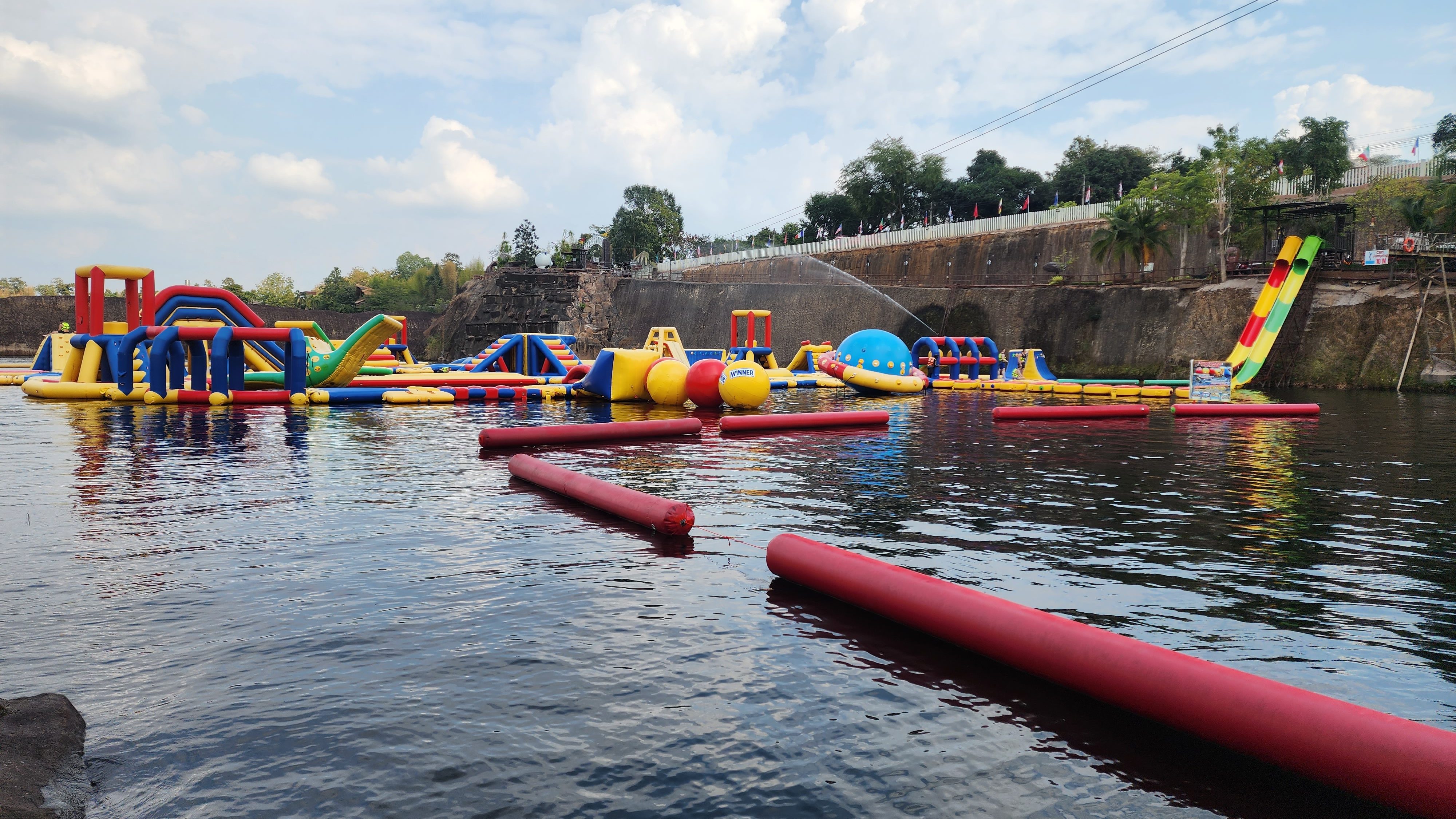A large and colourful inflatable water park in a man made canyon
