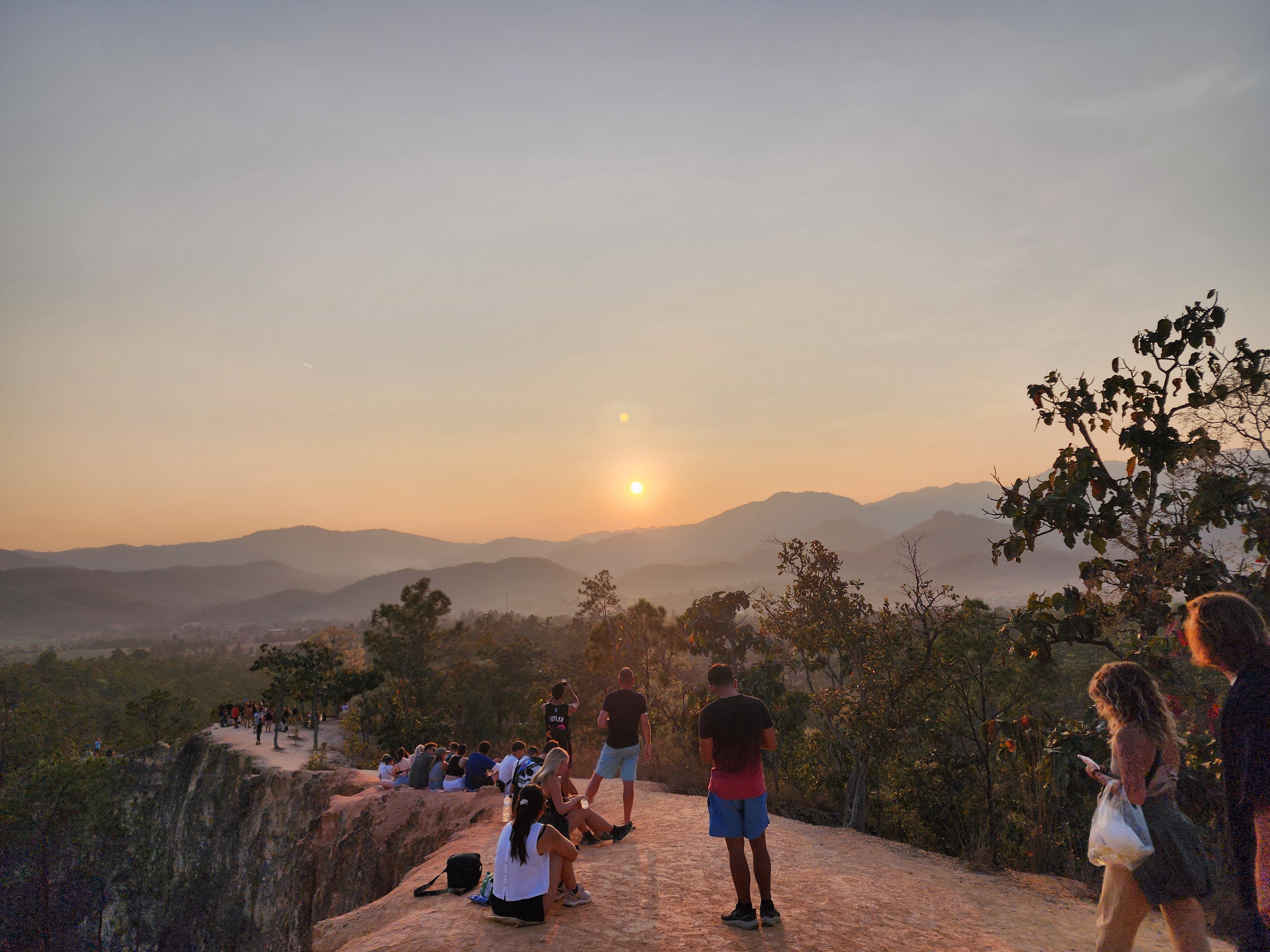 People sitting and watching the sunset in Pai, Northern Thailand.