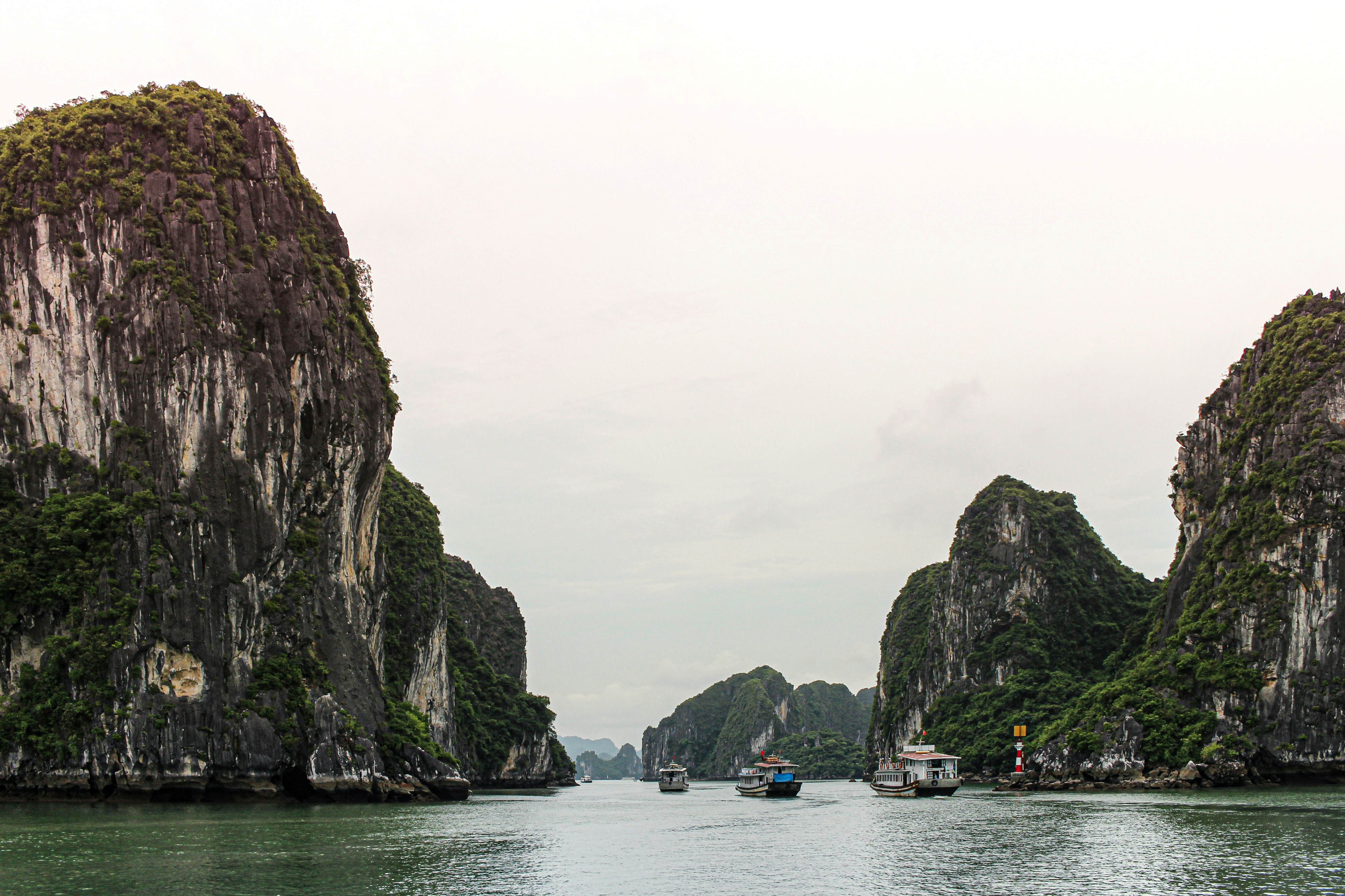 Ships sailing through Ha Long Bay on a cloudy day